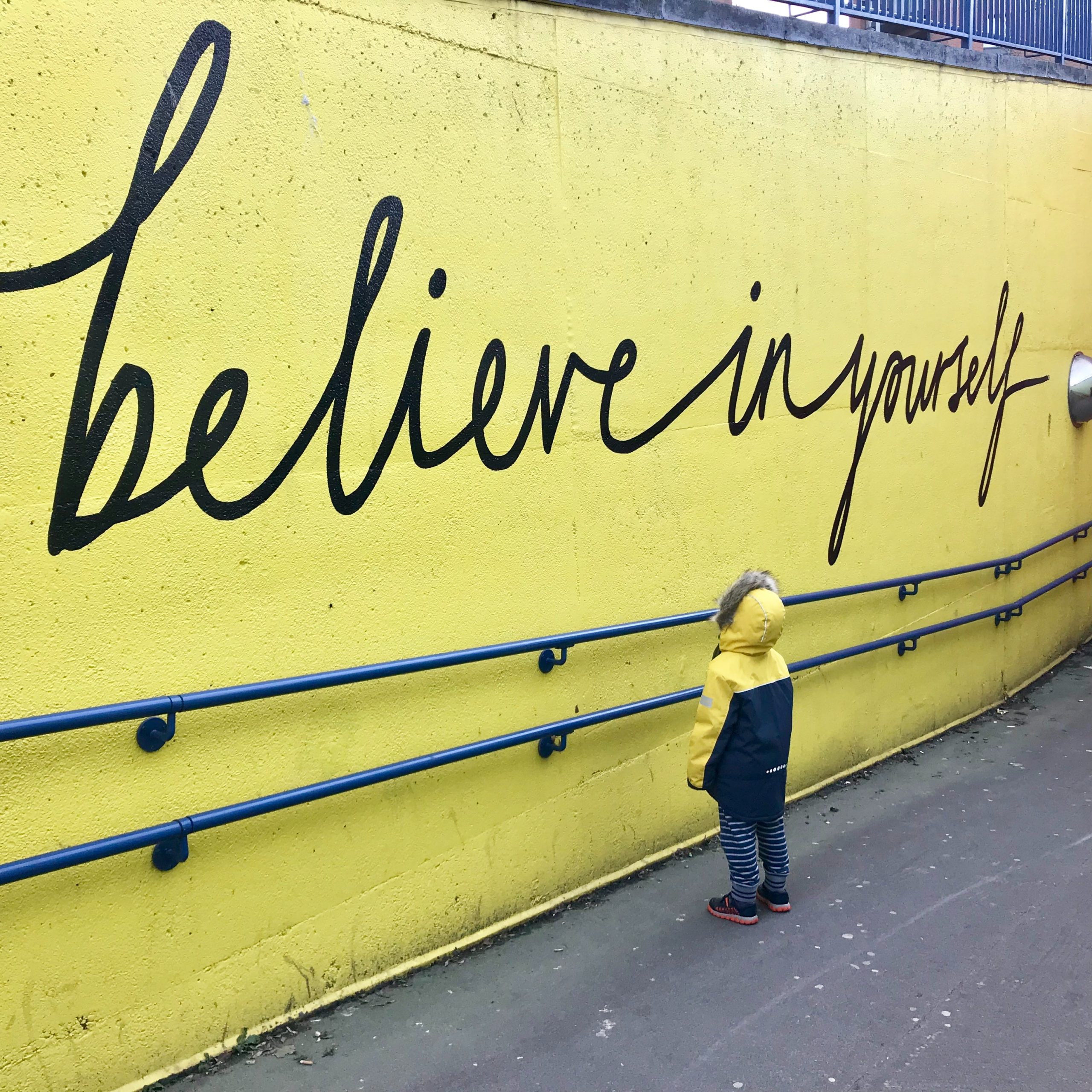 Driving Test Mallow showing a boy looking at yellow wall with believe in yourself graffiti